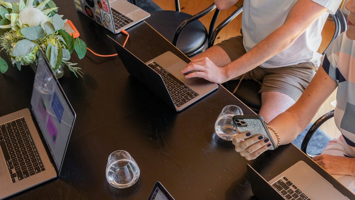 Team sitting around a table with laptops
