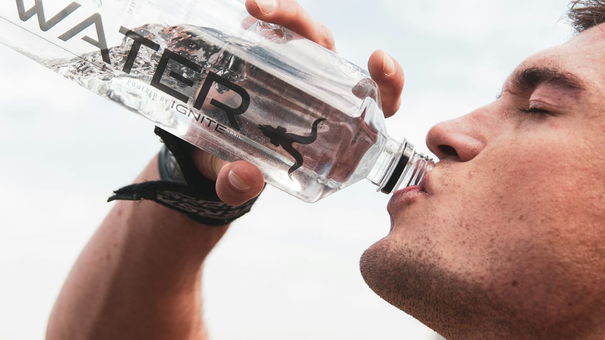 Man drinking from a water bottle after a workout