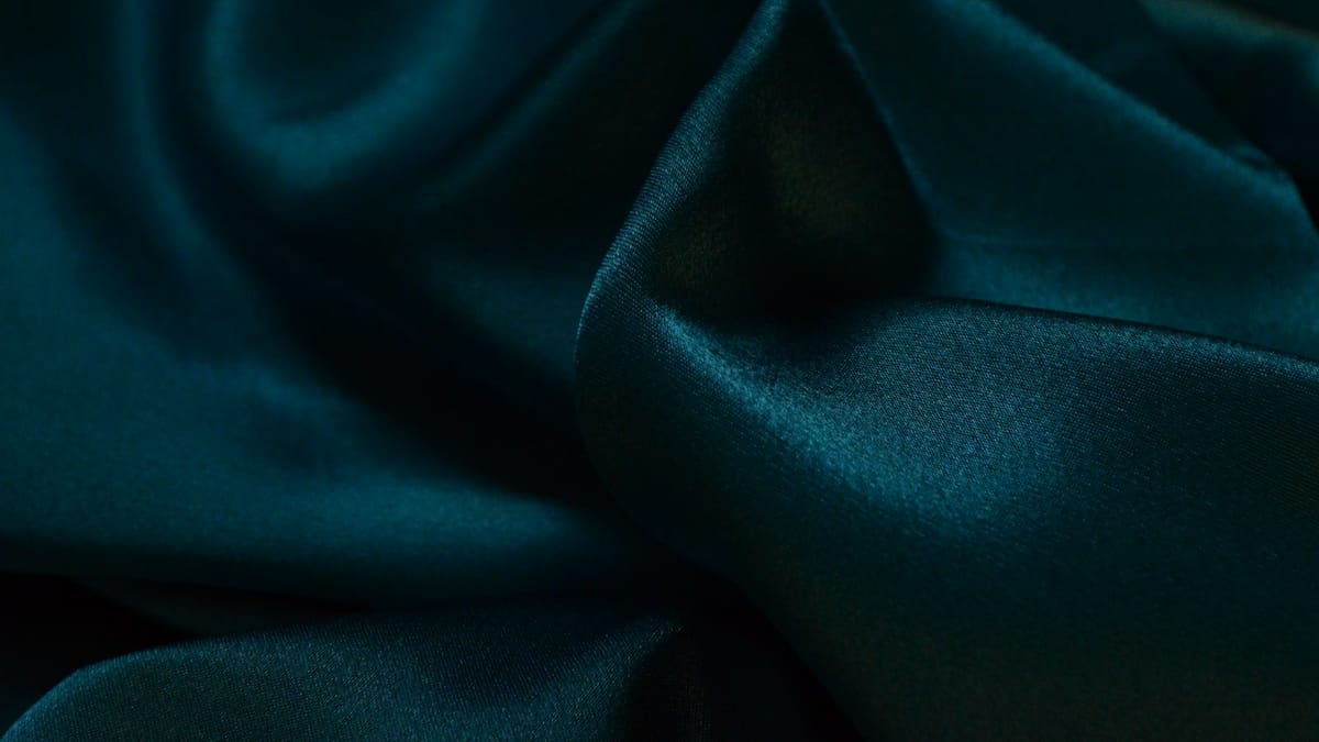 Folds of red silk fabric against white textile