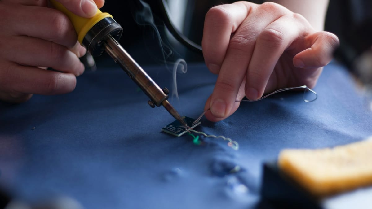 Technician using a soldering iron on a circuit board