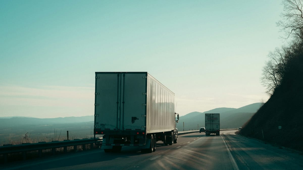 Two semi-trucks driving on a highway