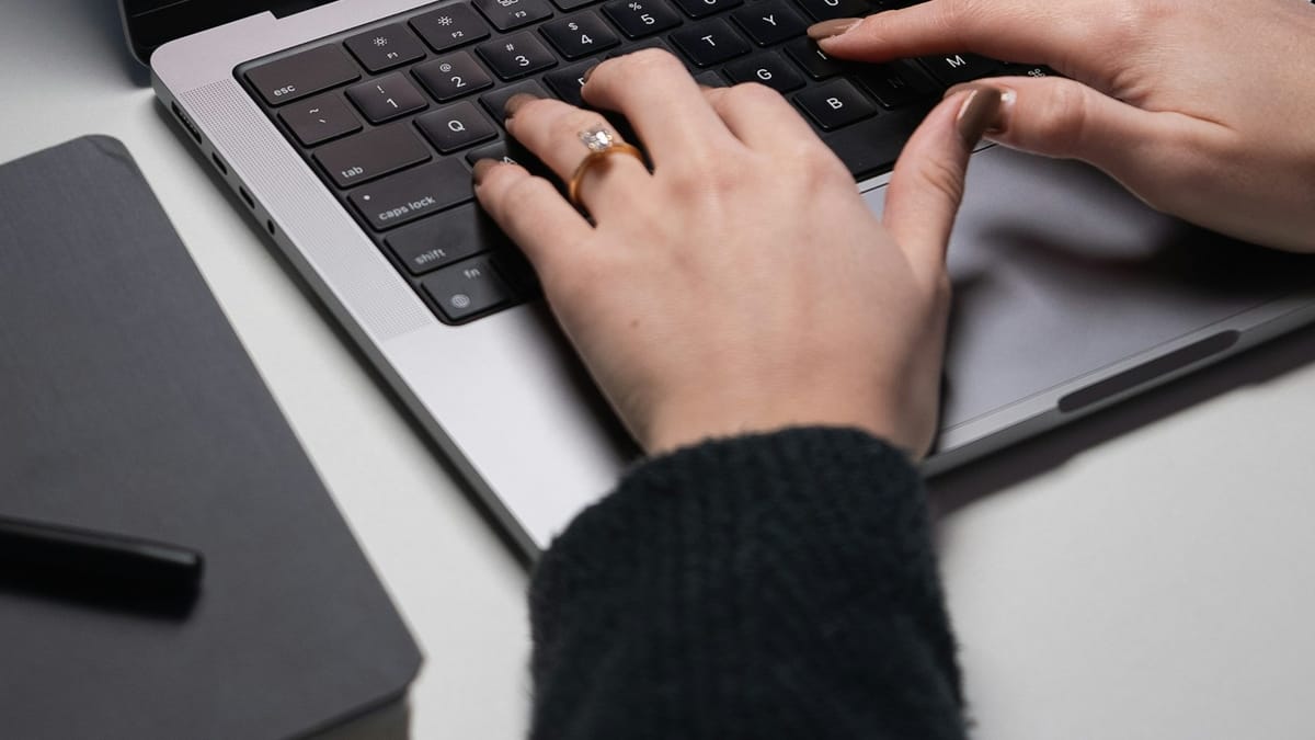 Person typing an email on a laptop at a desk